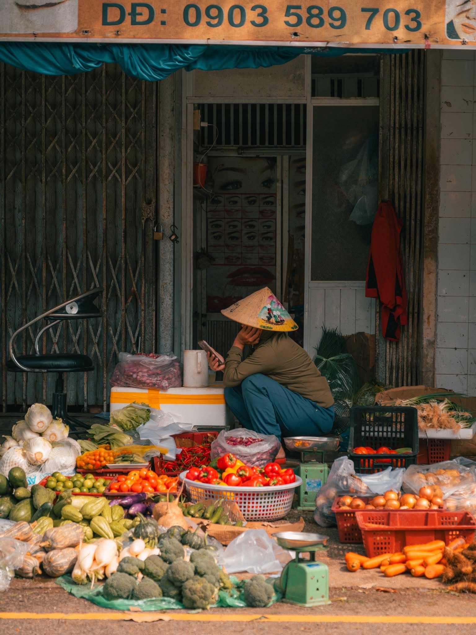 Người phụ nữ bán hàng đội nón lá giữa sạp rau quả ở chợ Đông Ba Huế