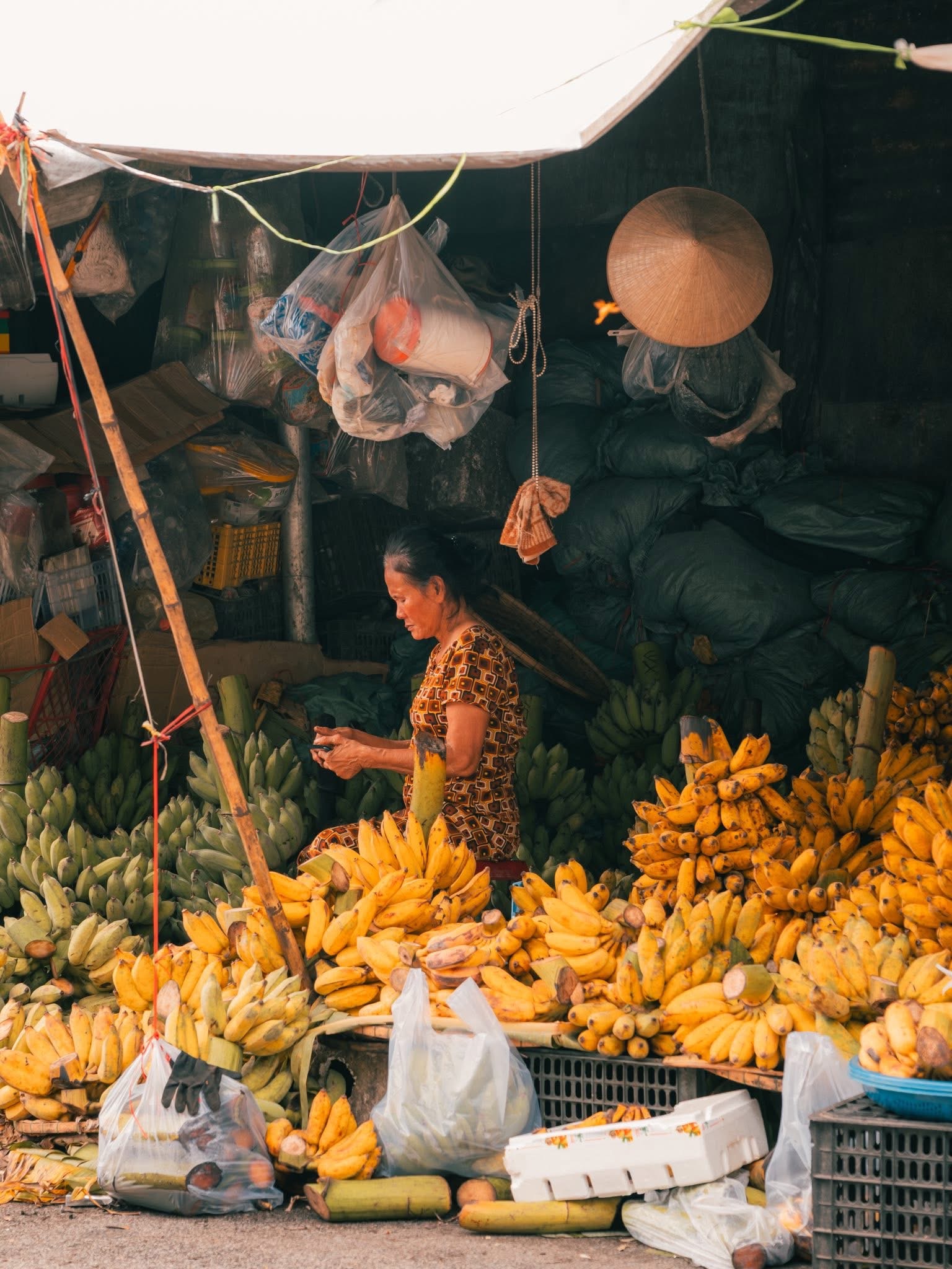 Người phụ nữ bán chuối đếm tiền tại sạp hàng chợ Đông Ba Huế