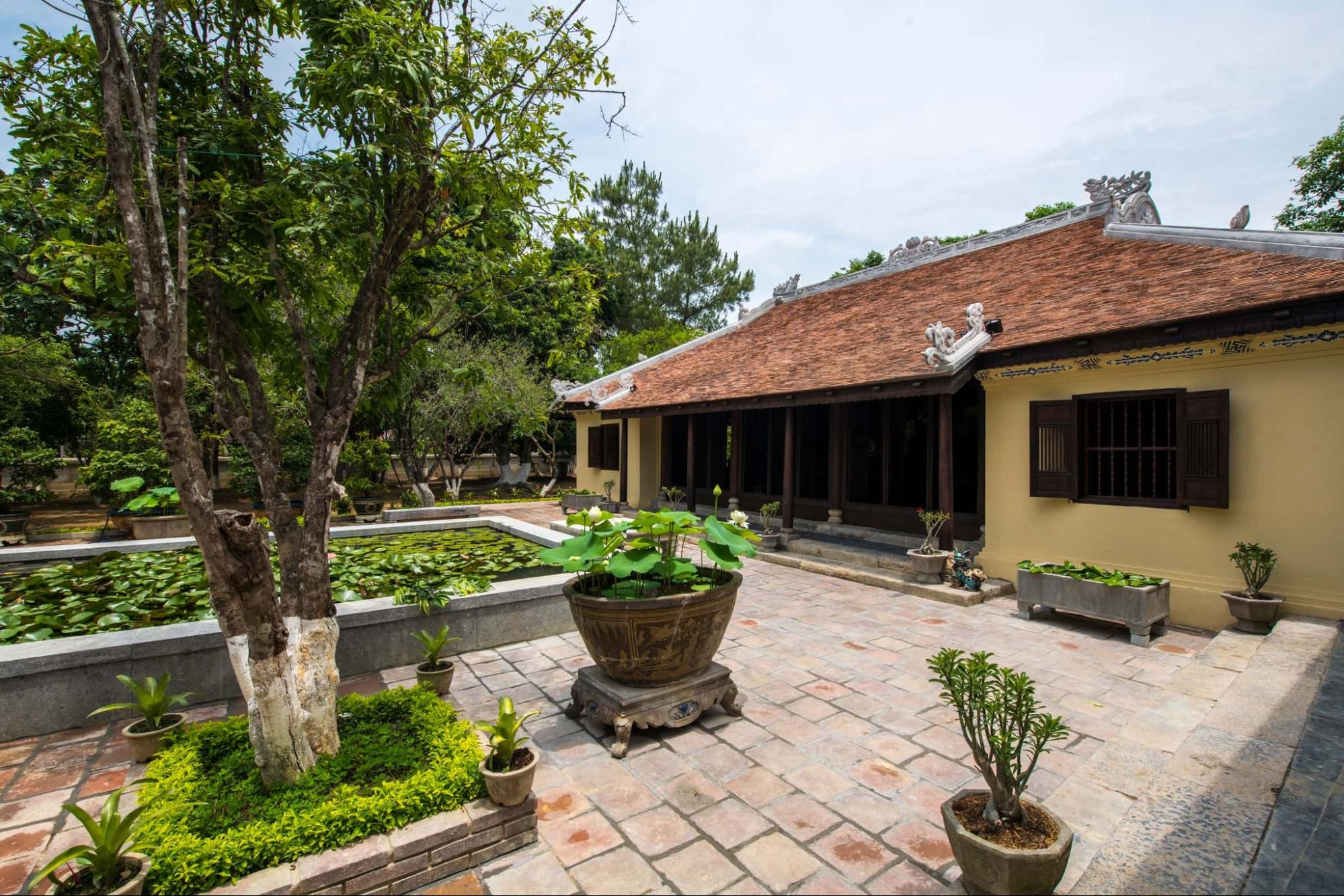 Nhà rường Huế truyền thống bên hồ sen và sân gạch cổ — tài sản di sản không thể tạo thêm