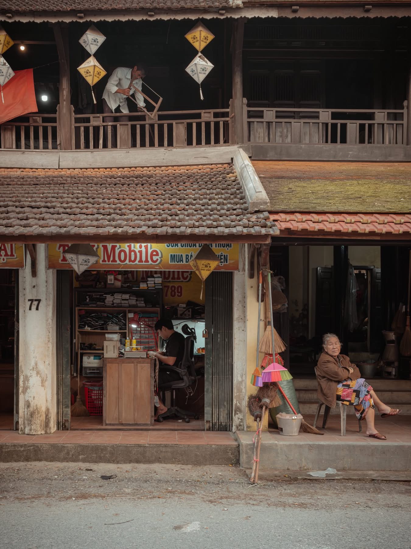Cụ bà ngồi nghỉ trước hiên nhà gỗ cổ ở Huế — nếp sống chậm thường nhật Cố Đô